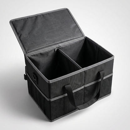 La boîte de coffre StaySpace ouverte sur fond clair : couvercle relevé, séparateur central, poches filet latérales et poignées de transport